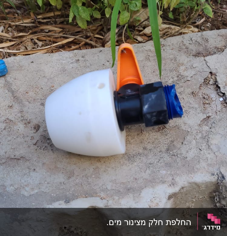 חלק פלסטיק לבן עם חיבורי צנרת על אבן